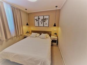 a bedroom with a white bed with two night stands at Emanuela in Jelsa