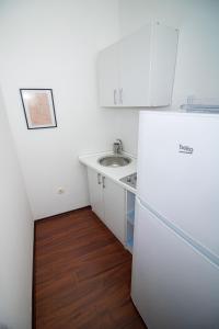 a small kitchen with a sink and a refrigerator at Miro apartments in Mostar