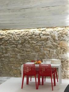 a table with two chairs and a table with fruit on it at IL VICOLETTO Luxury Apartments in Augusta