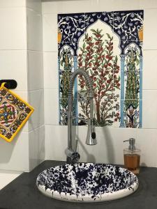 a sink in a room with a painting on the wall at IL VICOLETTO Luxury Apartments in Augusta