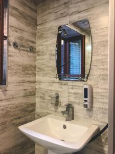 a bathroom with a sink and a mirror at Philia's Guest House in Sighnaghi