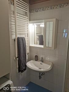 Affascinante appartamento ai piedi dell'ovovia في كورمايور: حمام مزود بحوض ومِرآة