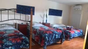 a bedroom with two bunk beds and a bed with a comforter at Hostal familiar Villa Nome in Penonomé