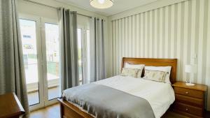 a bedroom with a bed and a large window at Alice by Check-in Portugal in Albufeira