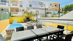 a balcony with a table and chairs and a swimming pool at Alice by Check-in Portugal in Albufeira