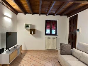 a living room with a couch and a flat screen tv at B&B Ca' Cammello in Ferrara
