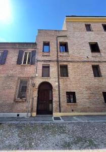 duży ceglany budynek z drzwiami i oknami w obiekcie B&B Ca' Cammello w mieście Ferrara