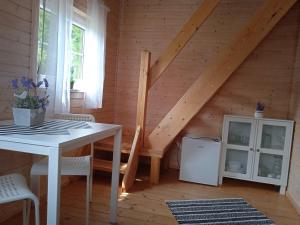 Cette chambre dispose d'une table blanche et d'un escalier. dans l'établissement Domek Letniskowy "Domek Lawendowy", à Pisz