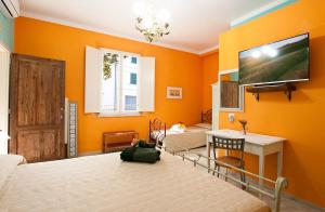 a bedroom with orange walls and a tv on the wall at affittacamere il sole in Montopoli in Val dʼArno