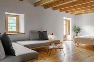 ein Wohnzimmer mit 2 Betten und einem Tisch in der Unterkunft Cal Calsot Casa Rural "Adults Only" in Montellá