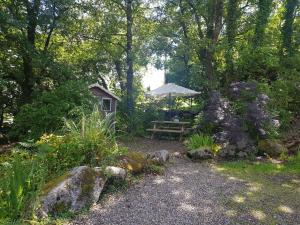 una mesa de picnic con una sombrilla en el jardín en Hollybanks, en Moycullen