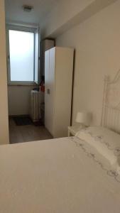 - une chambre avec un lit blanc et un réfrigérateur dans l'établissement Masa House, à Palerme