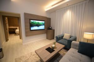 a living room with a couch and a tv on a wall at شقق ودف للشقق المخدومة Wdf Serviced Apartments in Jeddah +16 photos