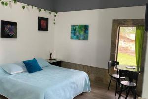 a bedroom with a bed and a table and a window at Moderna cabaña en medio de la naturaleza in Santandercito