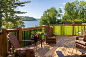 a deck with chairs and a view of a lake at Woodhaven - Seaside Accommodations in Waweig