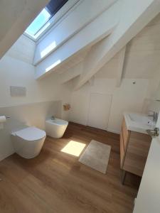 a bathroom with a toilet and a sink and a skylight at Blu Sea apartments in Pietra Ligure +53 photos