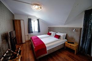 um quarto com uma cama grande e um cobertor vermelho em Hotel Sonne Interlaken-Matten em Interlaken