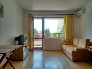 a living room with a couch and a television at Morski Briz in Balchik