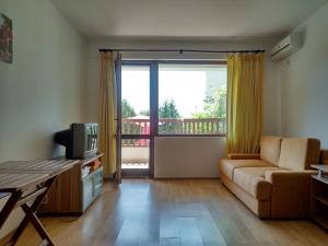 a living room with a couch and a television at Morski Briz in Balchik +47 photos