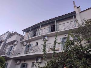 a white apartment building with a balcony on it at Grecos ART SKIATHOS in Skiathos