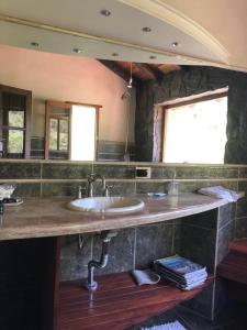 uma casa de banho com um lavatório e um espelho grande em Casa boutique en cuesta blanca em Villa Icho Cruz