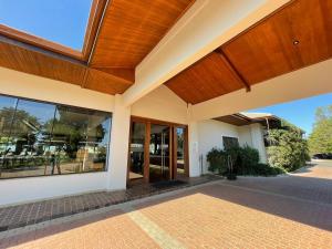 a building with glass doors and a roof at Japy Golf Resort Hotel in Cabreúva +78 photos