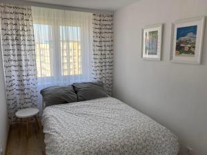 a bedroom with a bed and a chair and a window at Krasickiego 12 Gdynia Centrum in Gdynia