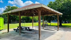 een houten paviljoen met een picknicktafel en een schommel bij REGENCY INN & SUITS in Houston