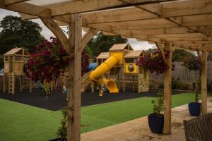 a playground with a yellow slide in a yard at The Black Dog Inn in Broadmayne