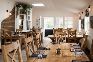 uma sala de jantar com mesas e cadeiras de madeira em The Black Dog Inn em Broadmayne