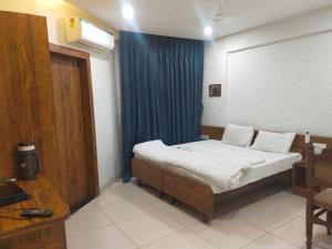 奥兰加巴德Hotel Kartiki的一间卧室配有床和蓝色窗帘