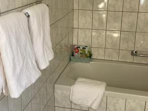 y baño con toallas blancas y bañera. en Haus Kroneck-Salis Gästeappartement, en Bad Iburg