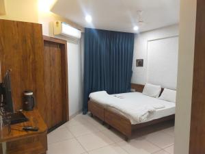 奥兰加巴德Hotel Kartiki的一间卧室配有床和蓝色窗帘