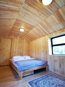 NarewkaにあるWagon Przystanek Gnilecの木造キャビン内のベッド1台が備わるベッドルーム1室を利用します。