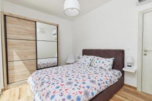 a bedroom with a bed and a large mirror at Petrovic apartmani in Tivat