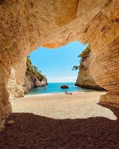 a view of a beach through a rock cave at Luxury Sea House in Rodi Garganico