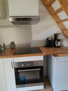 a kitchen with a stove and a counter top at Studio calme et lumineux avec terrasse in Auxelles-Haut