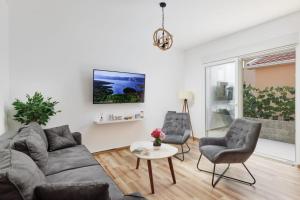 a living room with a couch and two chairs and a table at Petrovic apartmani in Tivat