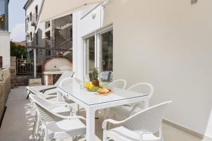 a white table and chairs on a patio at Petrovic apartmani in Tivat