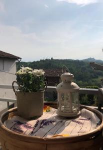 un tavolo con lanterna e una pianta in vaso sul balcone di Dai Biancot a Camagna Monferrato