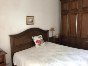 un letto con testiera in legno e un cuscino sopra di Dai Biancot a Camagna Monferrato