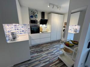 a kitchen with white cabinets and a floor with tiles at Seemannsbraut in Kellenhusen