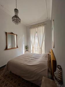 Un dormitorio blanco con una cama grande y una ventana en Elegante e accogliente appartamento a Torino, en Turín