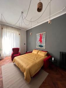 1 dormitorio con 1 cama grande y 1 silla roja en Elegante e accogliente appartamento a Torino, en Turín