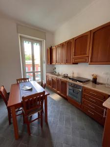una cocina con armarios de madera y una mesa con sillas. en Elegante e accogliente appartamento a Torino, en Turín