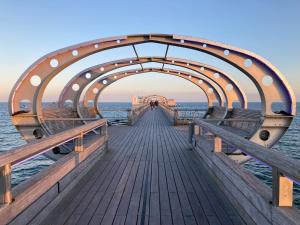 a wooden boardwalk leading to the ocean with a pier at Seemannsbraut in Kellenhusen