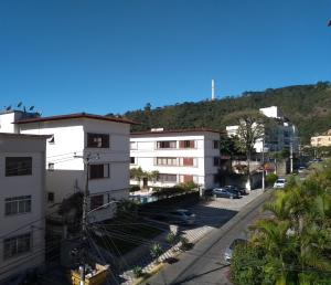 een stadsstraat met gebouwen en een heuvel op de achtergrond bij Apartamento Jardim Cascata in Teresópolis