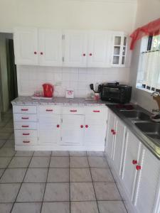 - une cuisine blanche avec des placards blancs et un évier dans l'établissement Edward Cabana, à Margate