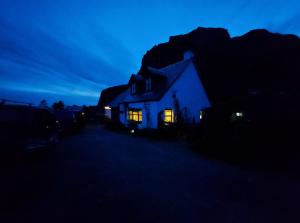 Una casa de noche con las luces encendidas en Garragh Mhor, en Oban