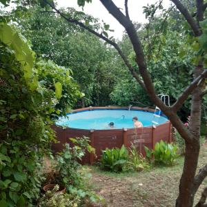 un uomo in piedi in una vasca idromassaggio in un giardino di Orange Cube Apartment - Self check in - Free parking a Fiume (Rijeka)